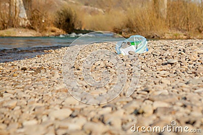 River pollution near the shore, garbage near the river, plastic food waste, contributing to pollution Stock Photo
