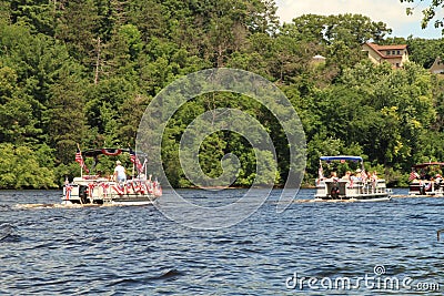 River pontoon parade passes a home in Eau Claire Wisconsin Editorial Stock Photo