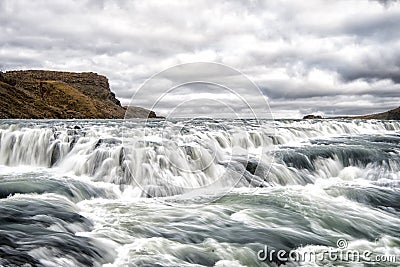 River rapids in reykjavik, iceland. Water stream flow. Water falls on cloudy sky. Velocity and turbulence. Wild nature landscape. Stock Photo