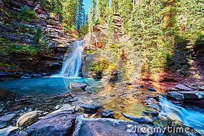 River rocks and canyon with blue vibrant waterfall Stock Photo