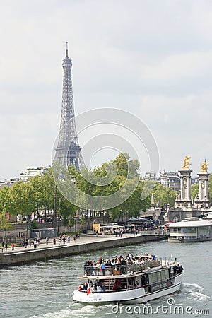 On the river Seine sailing ship with cheerful tourists Editorial Stock Photo