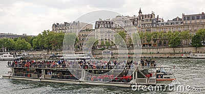 On the river Seine sailing ship with cheerful tourists Editorial Stock Photo