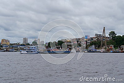River view of the busy port of Manaus with a lot of ferries and boats. and some skyscrapers visible in the background. Location: Editorial Stock Photo