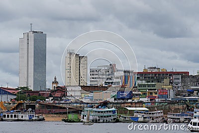 River view of the busy port of Manaus with a lot of ferries and boats. and some skyscrapers visible in the background. Location: Editorial Stock Photo