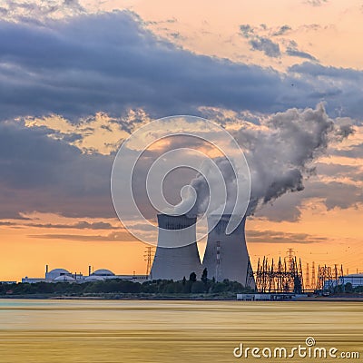 Riverbank with nuclear power plant Doel during a sunset with dramatic clouds, Port of Antwerp Stock Photo