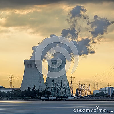 Riverbank with nuclear power plant Doel during a sunset with dramatic cluds, Port of Antwerp Stock Photo