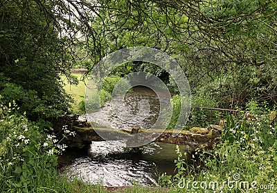 Rivers - River Windrush flowing under a stone footbridge Stock Photo