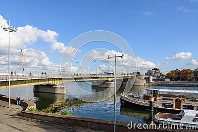 riverside of Meuse river, boat at pier and background of cityscape and Wilhelminabrug bridge in Maastricht, Netherlands. Editorial Stock Photo