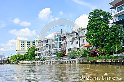 Riverside residential buildings with blue sky background at Chao Phraya river, Bangkok, Thailand Stock Photo