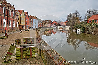 The riverside river Wensum with colorful houses and the Fye Bridge in the background Stock Photo