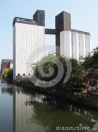 Riverside view of brighouse town with the former sugdens flour mill and grain silo now a large outdoor climbing wall and adventure Editorial Stock Photo