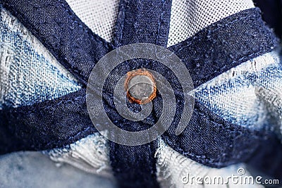 rivet on blue fabric with seams and stripes Stock Photo