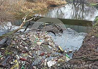 RIVNE, UKRAINE - DECEMBER, 2019: Trash in the nature. Bottles near the river. Pollution of environment Editorial Stock Photo