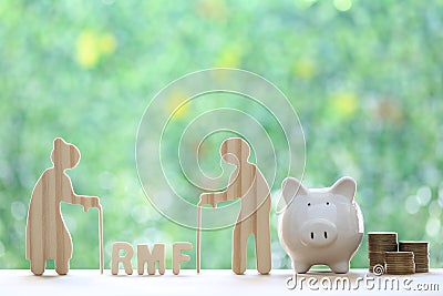 RMF - Retirement Mutual Fund, Senior man with RMF word and stack of coins money with piggy bank on natural green background, Save Stock Photo
