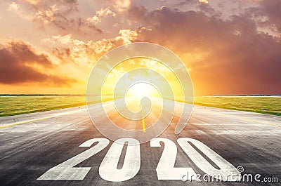 Road asphalt road with the inscription 2020 year with the rising sun in the morning. The concept of the beginning of new goals and Stock Photo