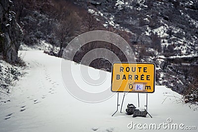 Road blocked sign on snow covered mountain road in Corsica Stock Photo