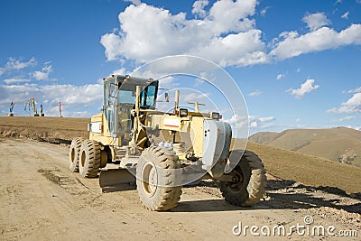 Road building machine with highland landscape Stock Photo