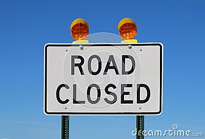 Road closed sign against a bright blue sky Stock Photo