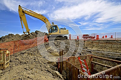 Road construction site with excavating machine Stock Photo