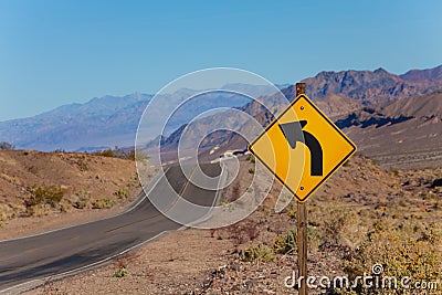 Road with curved arrow yellow sign, United States Stock Photo