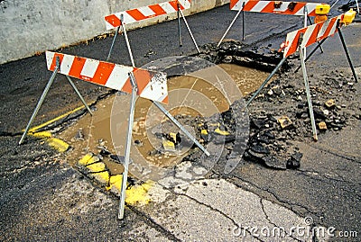 Road Damage from water underground water main pipe break Stock Photo