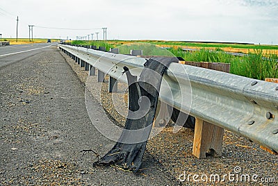 Tread from a truck tire hanging over a guard rail. Stock Photo