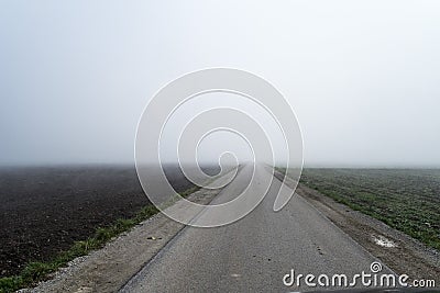 Road disappearing into fog. Stock Photo