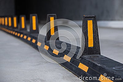 Road dividers with yellow stripes on road to underground garage Stock Photo