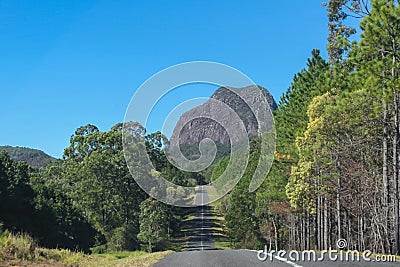 A road through the Glass Mountains of Queensland Australia that looks like it is headed straight toward a looming ancient volcanic Stock Photo