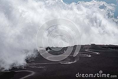 The road and jeep trucks above clouds on Mountain Etna volcano in Sicily, Italy. The biggest active volcano in Europe Stock Photo