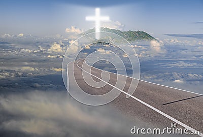 Road leading among the clouds to a glowing cross Stock Photo