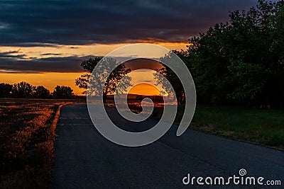 A Road Leading to a Beautiful Sunrise on the Plains of Colorado Stock Photo