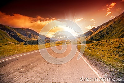 Road in the mountains landscape with bright sunset Stock Photo