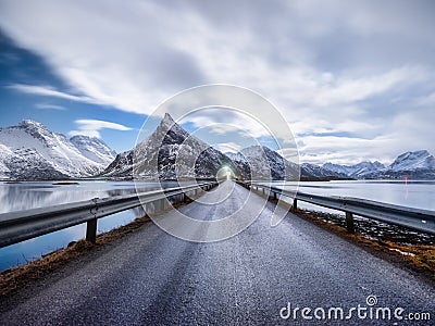 Road and mountains in the night, Lofoten islands, Norway. Asphalt and moonlight. Winter landscape with night sky. Long exposure sh Stock Photo