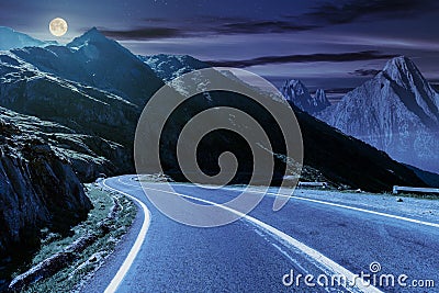 Road in mountains with rocky ridge at night Stock Photo