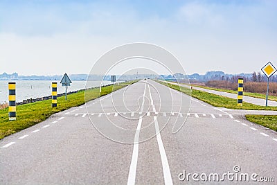 The road N701 between Almere and Lelystad in Netherlands splitting nature reservation and Markermeer Stock Photo
