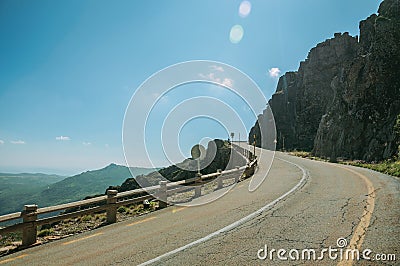 Road passing through rocky landscape in a sunny day Stock Photo