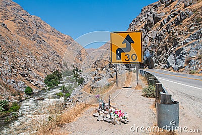 Road sign bend of road in mountains with speed limit. Stock Photo