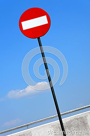 Road sign on a metal pole `Do not enter` sign against a blue sky with white clouds background. Stock Photo