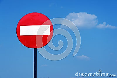 Road sign on a metal pole `Do not enter` sign against a blue sky with white clouds background. Stock Photo