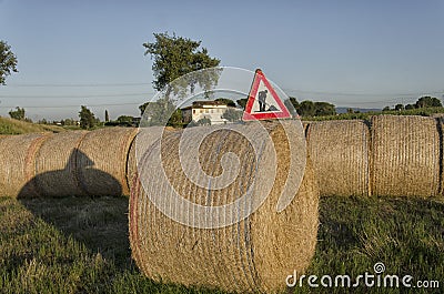 Road sign over straw round bale Stock Photo