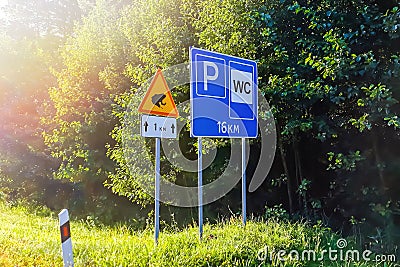 Road signs on highway. Parking and toilet after 16 km. Attention Amphibian toads and frogs crossing the road. Stock Photo