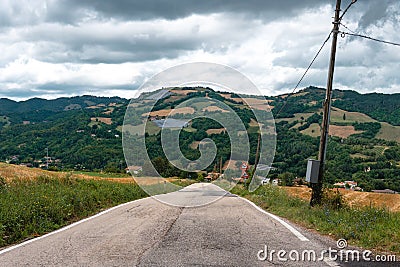 Road and Solar pannels in a remote area in the mountains on background. Small solar power plants. Rainy day. The clouds. Stock Photo