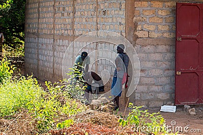 Unidentified local three men stand behind the shed in a village Editorial Stock Photo