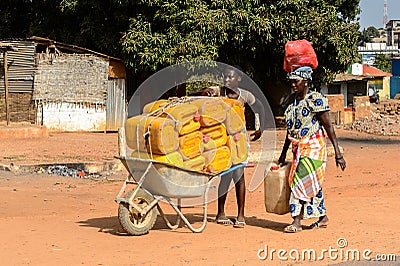 Unidentified local woman pulls a cart with jerrycans in a villa Editorial Stock Photo