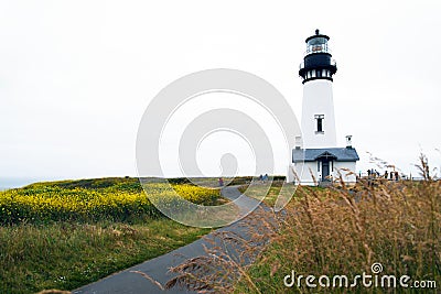 Road to high round lighthouse standing on promontory Pacific coa Stock Photo