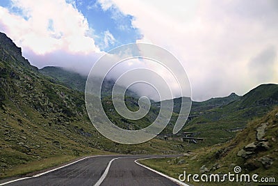 Road on the transfagarastan route in Romania in the summer. There are monutains around it Stock Photo