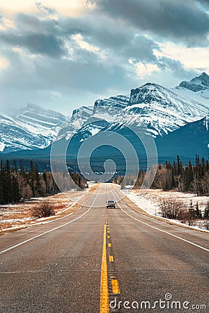 Road trip on highway between pine forest driving straight to rocky mountains in Icefields Parkway Stock Photo