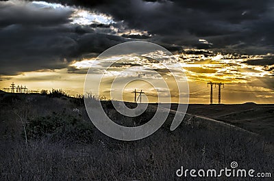 Road vanishing to the horizon under sun rays coming down trough the dramatic stormy clouds. Sunset at the mountain road. Azerbaija Stock Photo