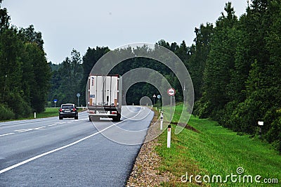 Road view. Cars are driving along the road. The road goes through the forest. Editorial Stock Photo